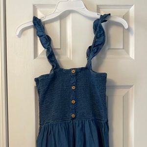 Denim sundress with ruffle straps and hem.  Top is elastic smocking. Size small